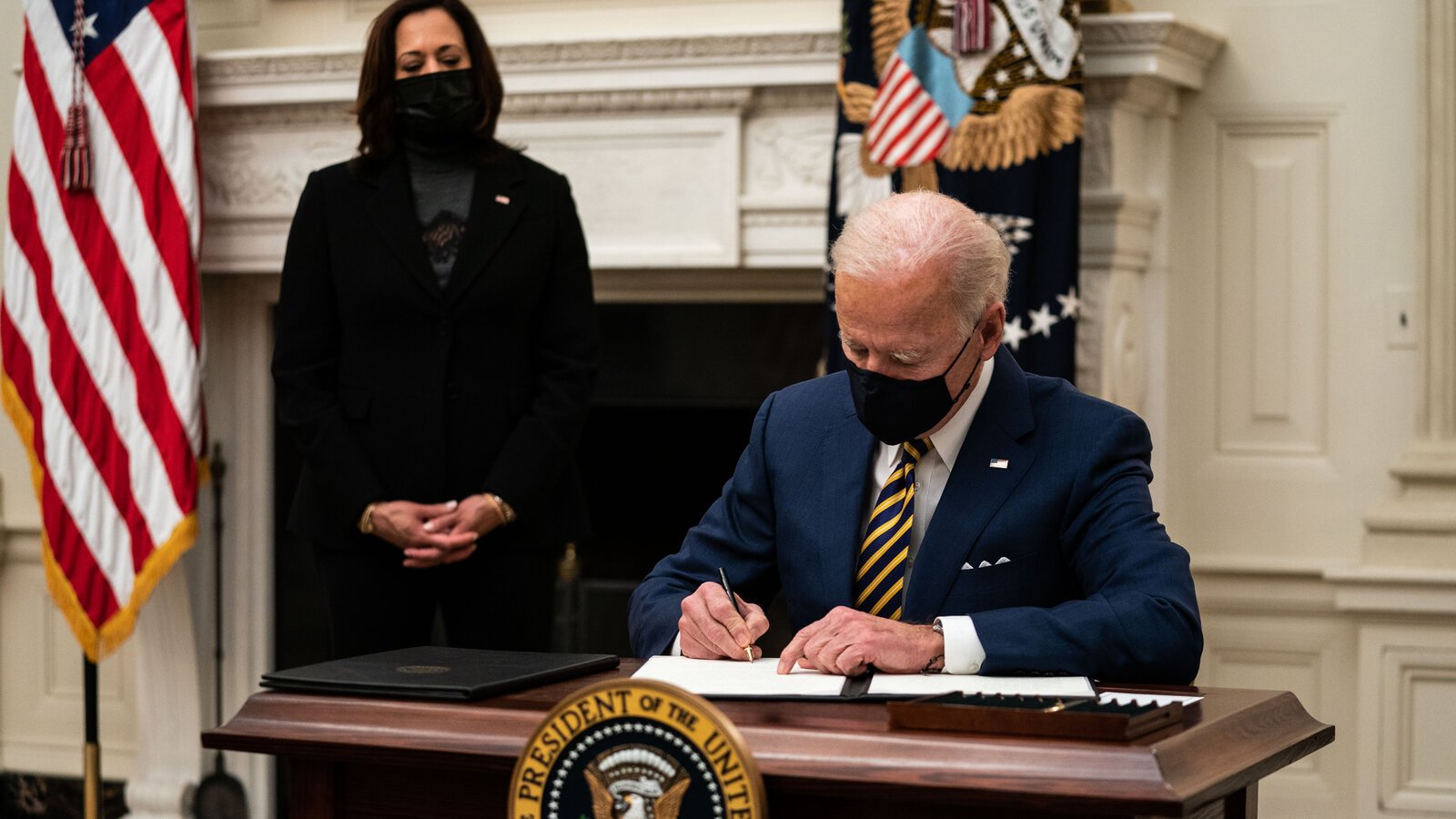 President Biden signing something into law. Photo Credit: The New York Times