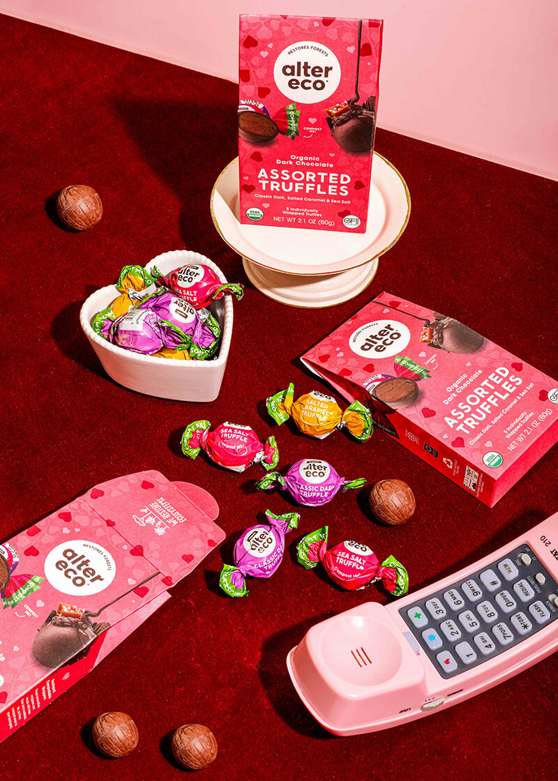 Alter Eco chocolate truffles packaging and candies on a red surface with a pink phone.