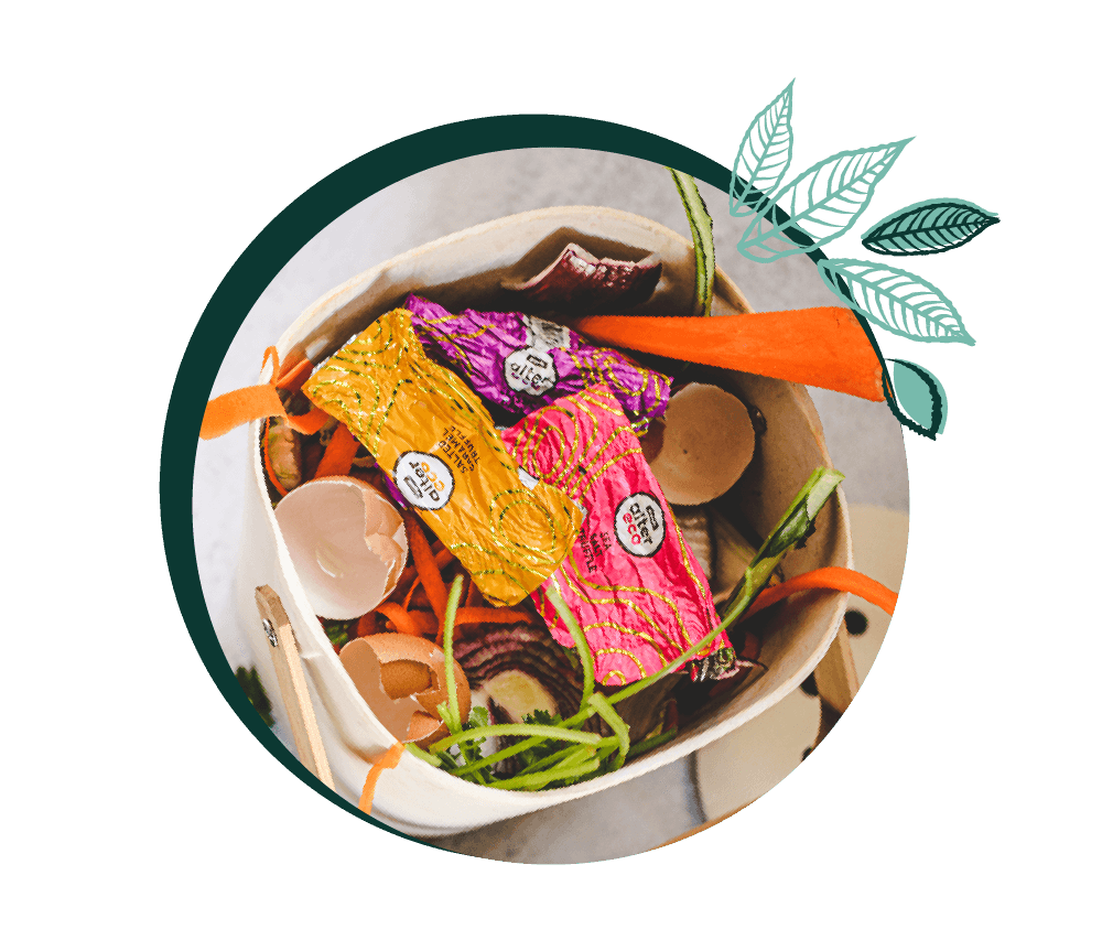 circle graphic showing the alter eco COMPOSTABLE wrapper in a composting bin in a kitchen on top of egg shells and vegetable scraps